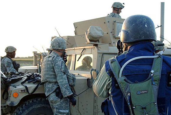 An embedded civilian journalist taking photographs of US soldiers An embedded civilian journalist taking photographs of US soldiers